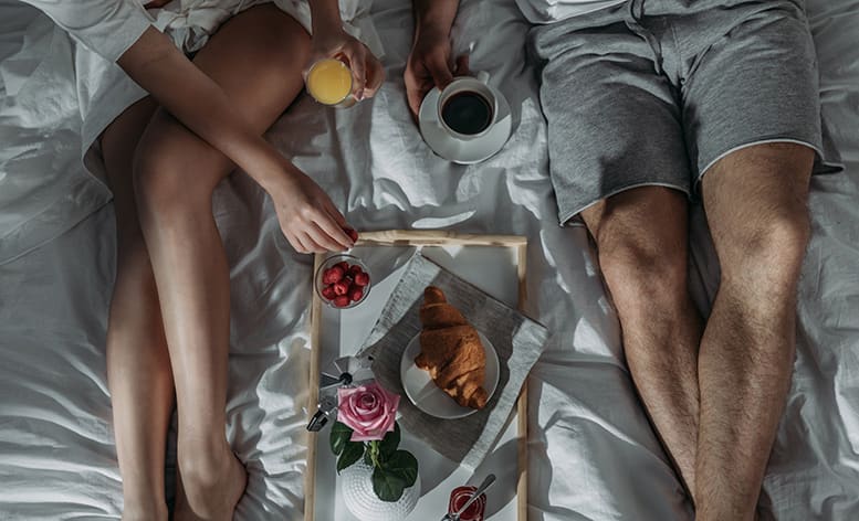 Couple in bed with Breakfast